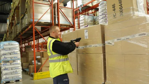 Mies skannaa laatikkoa varastossa